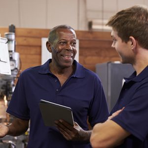 Engineer Training Male Apprentice On CNC Machine Engineer Training Male Apprentice On CNC Machine